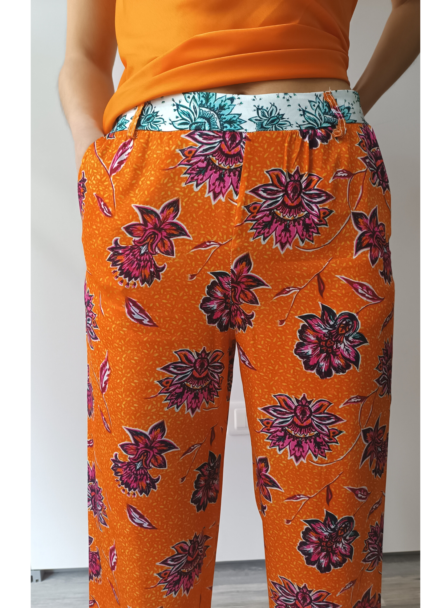 Pantaloni in fantasia floreale su fondo arancio