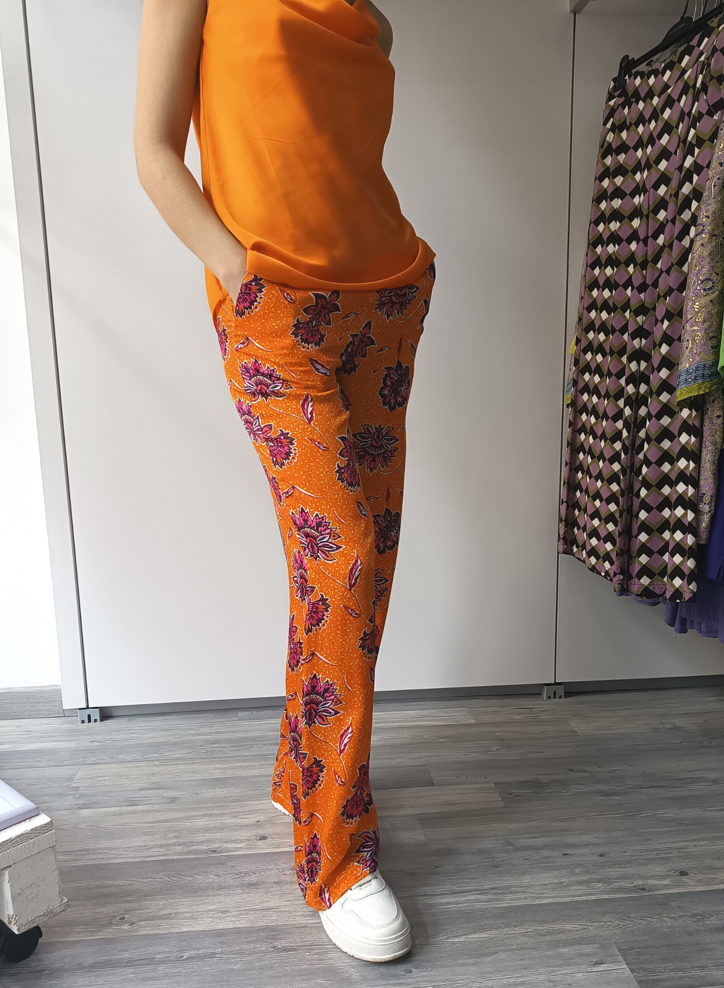 Pantaloni in fantasia floreale su fondo arancio