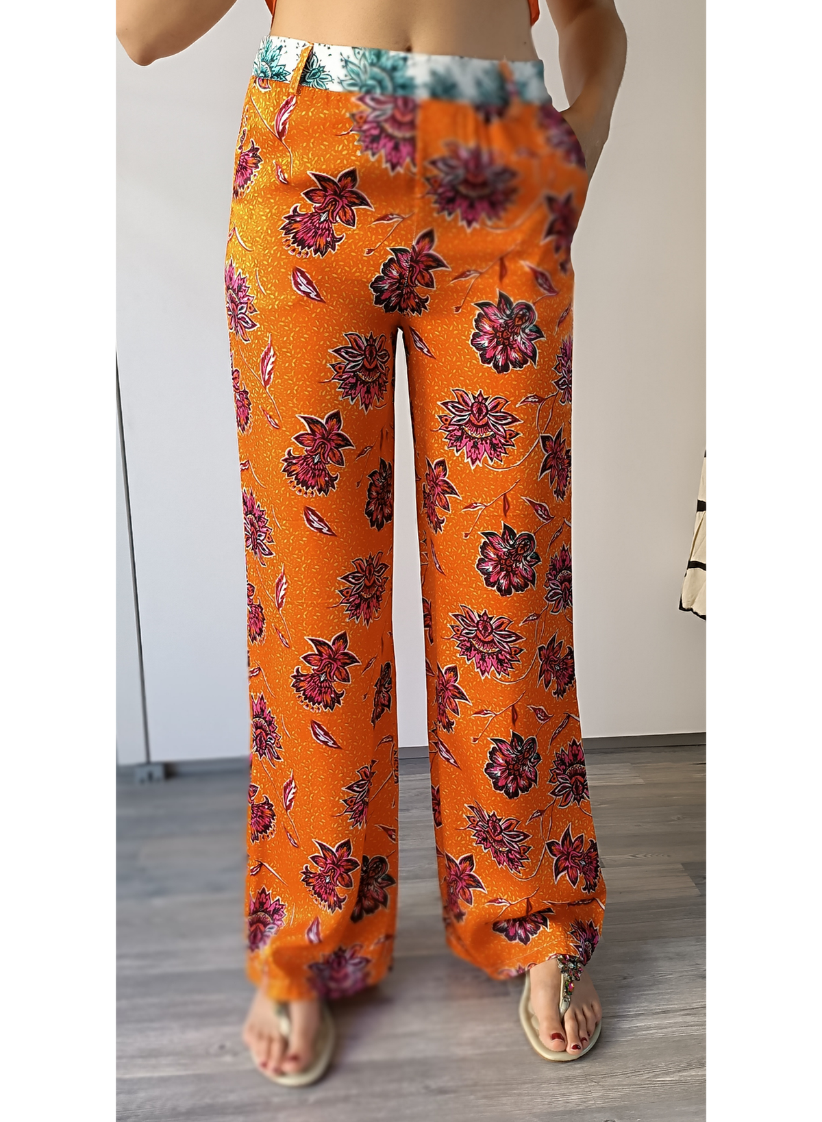 Pantaloni in fantasia floreale su fondo arancio